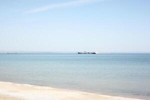 buques en un calma mar. minimalismo mar paisaje, tranquilo soleado día en el playa. negro mar, Bulgaria foto