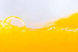 Close up bright orange juice splash texture for health and nature waves, Beautiful waves curve and little bubbles smooth for garphic design and background photo