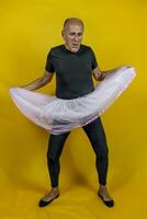 funny portrait of male ballet dancer. A mature ballet dancer dressed in tutu dancing clumsily photo