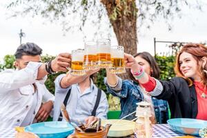 grupo de amigos teniendo divertido a jardín hogar fiesta - joven personas sonriente juntos Bebiendo cerveza foto