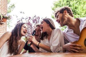 grupo de joven amigos teniendo divertido canto un canción foto