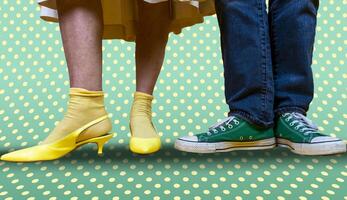 male and female legs with shoes in the style of the 50s on a background with colored polka dots photo