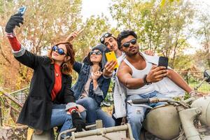 group of best friends take a selfie riding a vintage motorcycle with sidecar photo