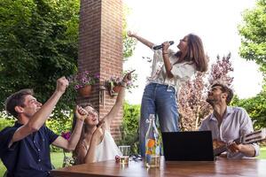 group of young friends having fun singing a song photo