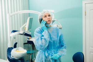 a female dentist is on the phone in her dental office photo