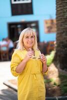 a blonde woman in a yellow summer dress stands on the street of the Old town of La Laguna on the island of Tenerife.Spain, Canary Islands photo