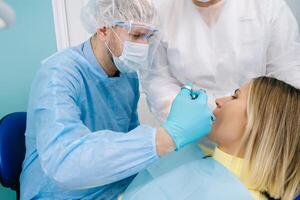 A female patient in dental glasses treats teeth at the dentist with ultraviolet light. dental fillings photo