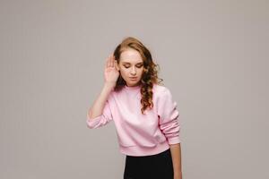 A beautiful girl on a gray background expresses her emotions, a woman with emotions photo