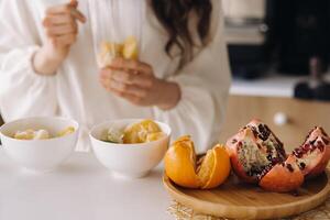 de cerca de el manos de un niña quien hace un desintoxicación cóctel de Fruta en el cocina. dieta para peso pérdida foto