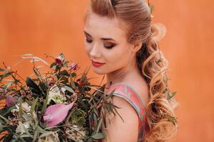 A young model girl in a beautiful dress with a bouquet of flowers in the countryside in France. Girl with flowers in the spring Provence village. photo