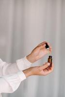 Close-up of female hands holding a bottle of essential oil, Aromatherapy photo
