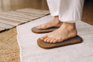 The man's feet are next to boards with nails. Yoga classes photo