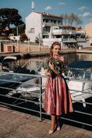 Young model girl in a beautiful dress with a bouquet of flowers on the beach in France. Girl with flowers in spring Provence on the French Riviera photo