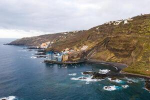 áspero rocoso acantilados en el norte de tenerife.negro playa en el canario islas rocas, volcánico rocas, atlántico Oceano foto