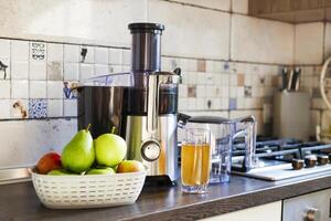 Fresh Juice Preparation with Electric Juicer in Kitchen photo