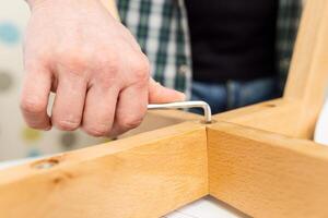 Self-assembly furniture concept. The young man himself assembling chairs photo