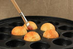 Brushing Takoyaki Pan with Oil photo