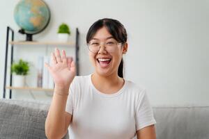 retrato de joven asiático mujer vistiendo ojo lentes sonriente y mirando a cámara foto