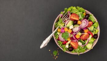 ai generado sano ensalada cuenco con plata tenedor en un llanura negro antecedentes foto