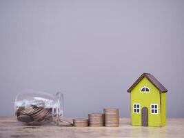 Miniature house and stack of coins. The concept of saving money for house, Property investment, House mortgage, Real estate photo