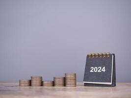 2024 escritorio calendario y apilar de monedas el concepto de negocio crecimiento, financiero inversión, mercado existencias, lucro devolver, dividendo y negocio fondo en año 2024 foto