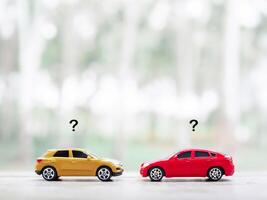 Toy cars with question mark icons. The concept of choosing suitable car for the future. photo