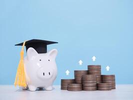 cerdito banco con graduación sombrero y apilar de monedas con flecha creciente. el concepto de ahorro dinero para educación, estudiante préstamo, beca, matrícula Tarifa en el futuro foto