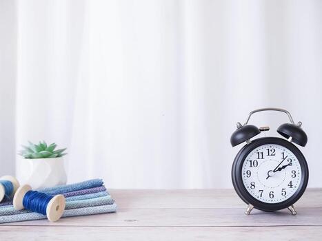 Black alarm clock and cactus with white curtain for background. Copy space for text, Office desk concept. photo