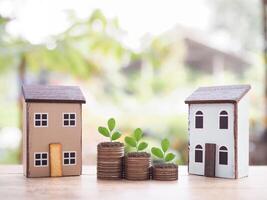 Miniature house and plants growing up on stack of coins. The concept of saving money for house, Property investment, House mortgage, Real estate. photo