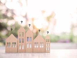 Miniature house with question mark icons.The concept of choosing suitable house for planning living in the future. Real estate photo