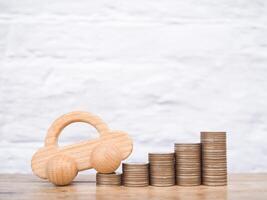 Toy car and stack of coins. The concept of saving money and manage to success transport business photo