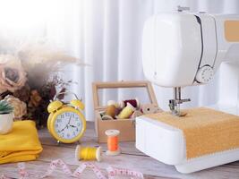 cerca arriba de coser máquina trabajando con amarillo tela, de coser accesorios en el mesa, puntada nuevo ropa. foto