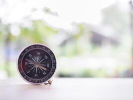 Close up compass on table in the sunset time. The concept of world tourism day, Searching the right directions and Travel photo