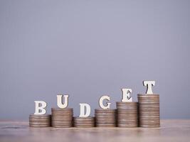 Wooden words with the BUDGET on stack of coins. The concept about budget planning and allocation photo