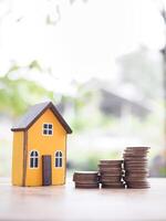 Miniature house and stack of coins. The concept of saving money for house, Property investment, House mortgage, Real estate photo