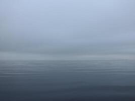 thick white fog over a calm sea, calm, silence, nothing visible, gradient background photo