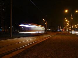 tranvía borroso movimiento paso por a noche, largo exposición foto