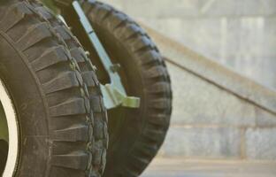 A close-up wheels of a portable weapon of the Soviet Union of World War II, painted in a dark green photo