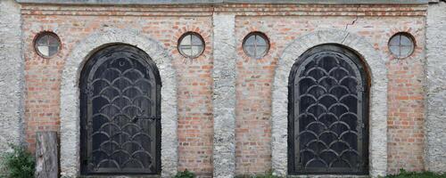 Very old solid door in brick stone wall of castle or fortress of 18th century photo