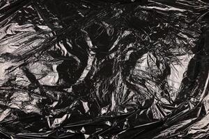 Texture of black plastic garbage disposable bag photo