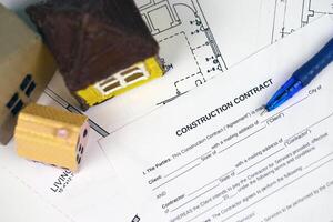 Residential construction agreement ready to sign with small toy houses and pen. Construction contract photo