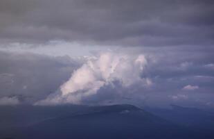 Morning view from the Dragobrat mountain peaks in Carpathian mountains, Ukraine. Cloudy and foggy landscape around Drahobrat Peaks photo