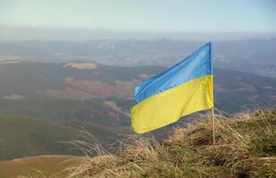 Ukrainian flag on top of Hoverla mountain in Ukraine photo