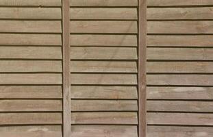 Horizontal texture of a wall from several rows of brown old wooden boards. Painted wooden wall in brown color photo