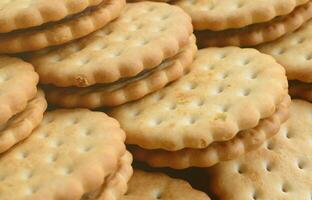 Detailed picture of round sandwich cookies with coconut filling. Background image of a close-up of several treats for tea photo