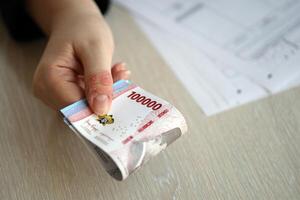 Female accountant hand give bunch of many indonesian rupiah money bills of new series photo