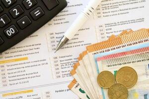 Filling italian tax form process with pen, calculator and euro money bills close up. Tax paying period photo