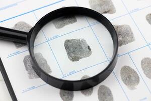 Fingerprints card police form on A4 tablet lies on office table with pen and magnifying glass photo