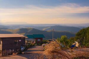 Aerial panorama, there is a well-known tourist destination with views of the mountains, village, and a farm. photo