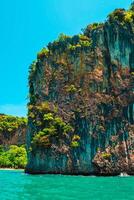 Aerial panorama of Thailand's verdant, lush tropical island, National Park Island, with blue and aquamarine the sea, and clouds shining by sunlight in the background. photo